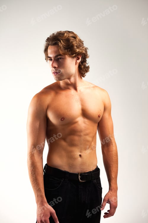 Preview: Young Athletic Man Showcasing Toned Abs in a Studio Setting for a Healthy Lifestyle Concept