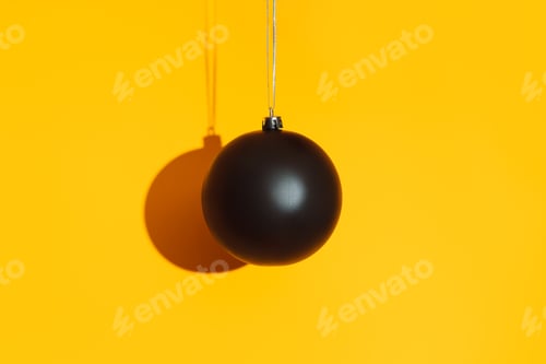 Preview: Black matte bauble with hard shadow on yellow background