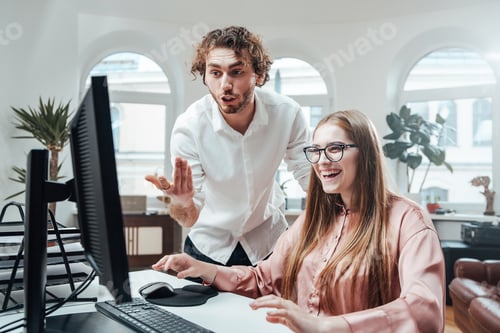 Preview: Woman laughs while her partner discuss something looking at screen