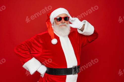 Preview: Santa Claus in sunglasses posing isolated on vivid red color background. Christmas promotion ad