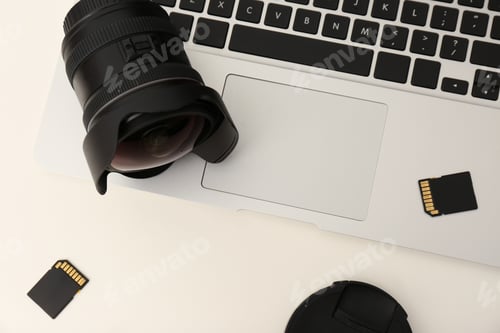 Preview: Laptop and professional photographer's equipment on table, top view