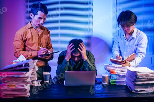 Preview: Three young businessmen work together on laptops in the office at night. They are stressed tired