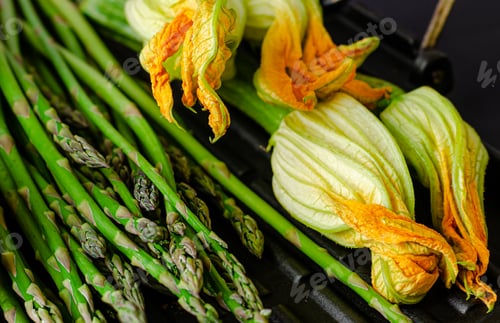 Preview: Close up of asparagus and zucchini with flowers. Healthy eating concept.