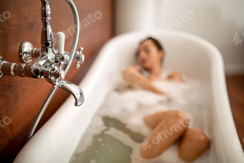 Preview: Beautiful young sensual woman enjoying pleasant bath with foam