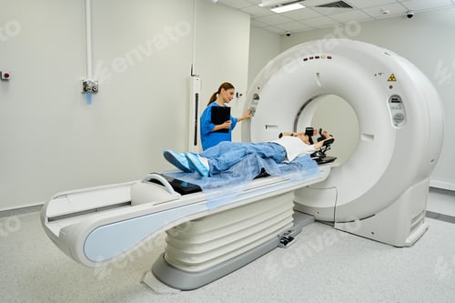 Preview: Professional female doctor assists patient during MRI scan in modern hospital setting