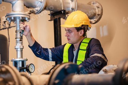 Preview: A team of engineers is examining the plumbing and water valves inside an industrial facility.