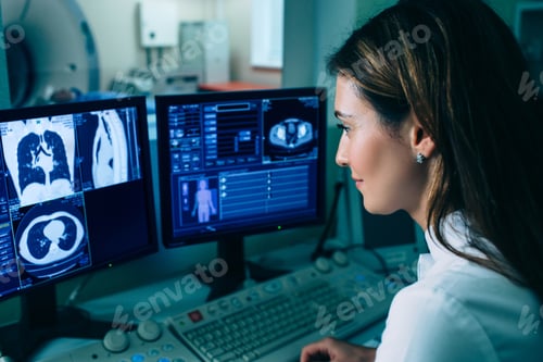 Preview: Radiologist reading a CT scan. Female doctor running CT scan from control room at hospital