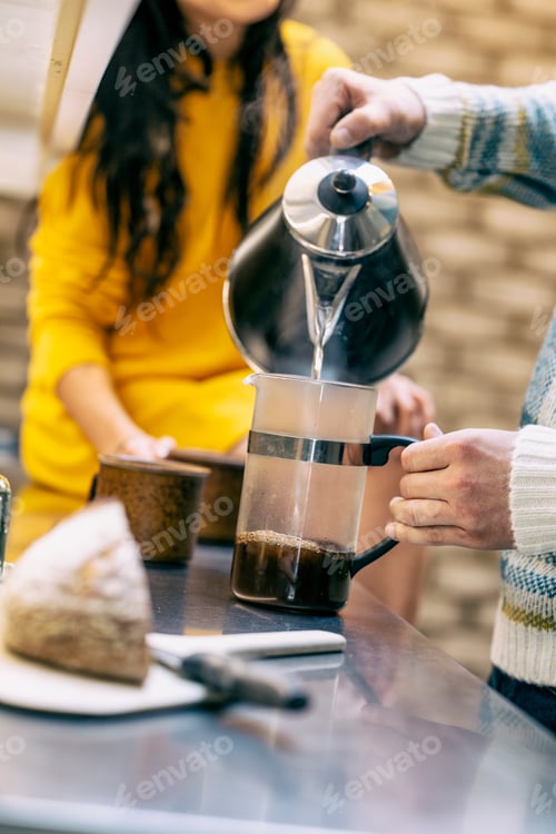 Preview: Hipster couple having coffee and talking in kitchen