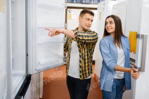 Preview: Young couple choosing refrigerator in store