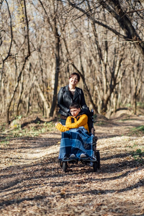 Preview: Mother and child with special needs enjoying nature walk in forest, accessibility in outdoor