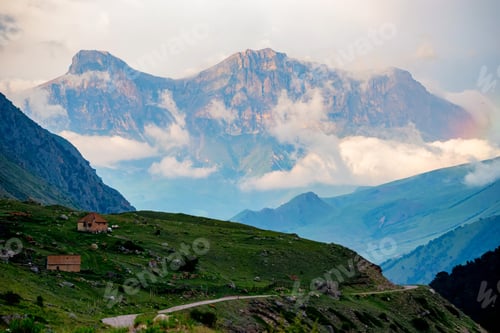 Preview: Scenic view of foggy mountains. Sunlit rocks and clouds