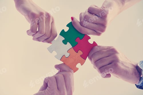 Preview: Group of business people assembling jigsaw puzzle
