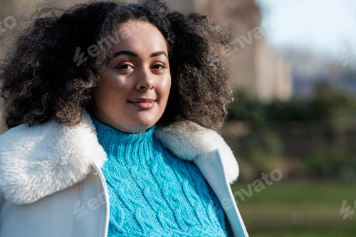 Preview: Portrait of smiling young curvy woman looking at camera outdoors.