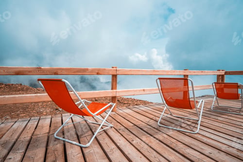 Preview: Red sunbeds in cloudy Alps
