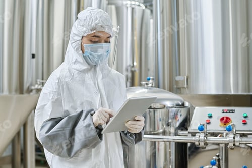 Preview: Engineer in protective wear working at chemical factory