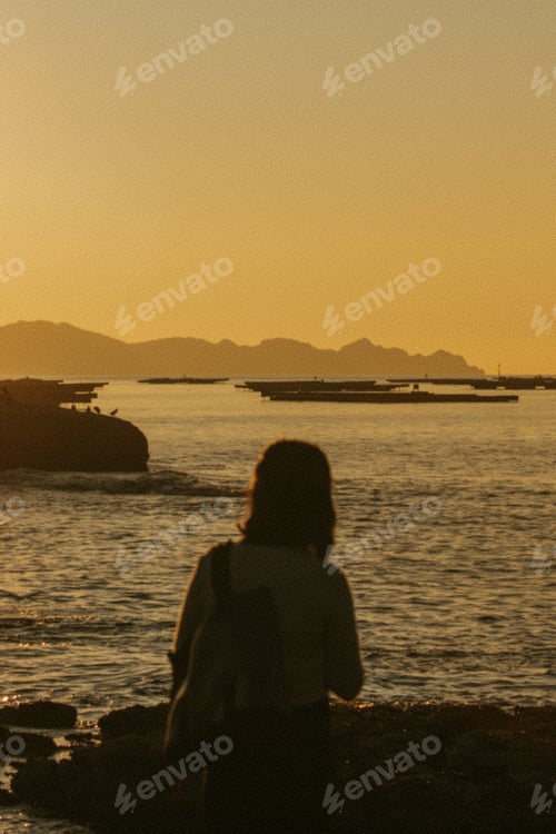Preview: Young woman in front of the ocean during a super sunny day with vintage styling