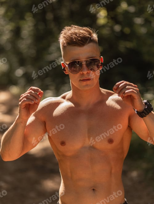 Preview: Cool handsome healthy muscular athletic man training outdoors