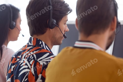 Preview: Rear view of diverse customer service executives working on computer at desk in office