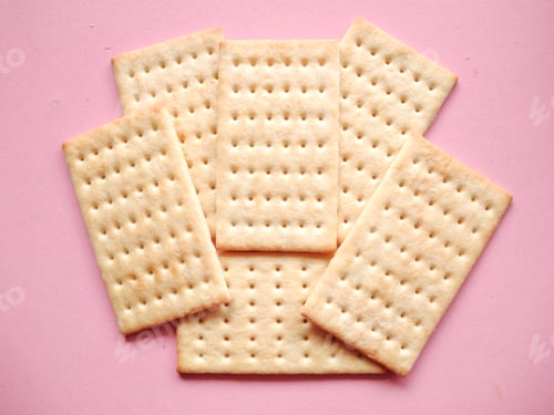 Preview: Rectangular crackers with perforations on pink surface background