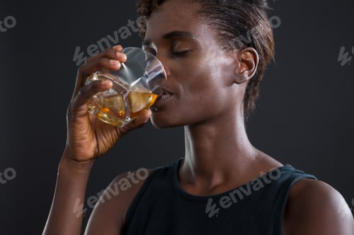 Preview: Androgynous man drinking whiskey from glass