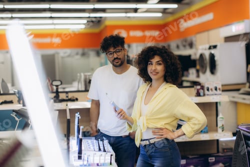 Preview: Smiling Customers Shopping for Electronics in a Modern Retail Store. A woman chooses a toothbrush