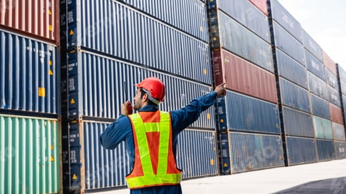 Preview: Engineer or foreman standing on the container yard warehouse talk on a portable radio.