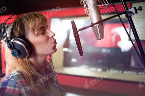 Preview: Young singer woman during music session at recording studio