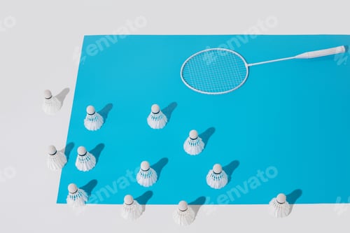 Preview: high angle view of white badminton racket and shuttlecocks on blue paper