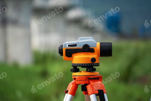 Preview: A surveying instrument is on a tripod in a grassy field
