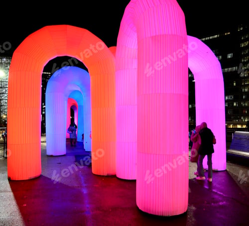 Preview: People walking between neon lights