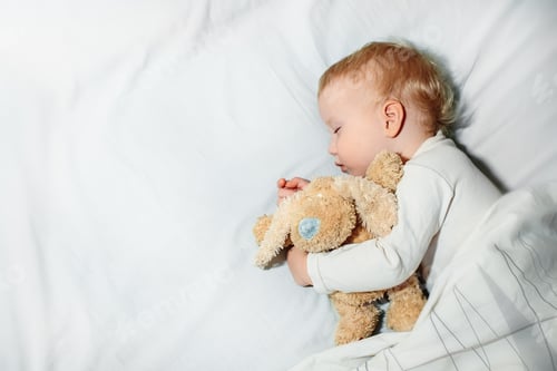Preview: Peaceful baby lying on a bed while sleeping