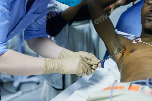 Preview: Cropped shot of a doctor sterilizing a patients chest in an emergency room