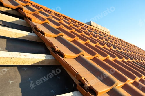 Preview: Overlapping rows of yellow ceramic roofing tiles mounted on wooden boards covering residential