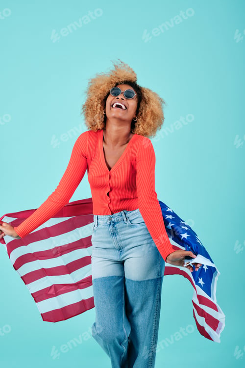 Preview: Cheerful afro woman holding a USA flag while celebrating Independence Day.