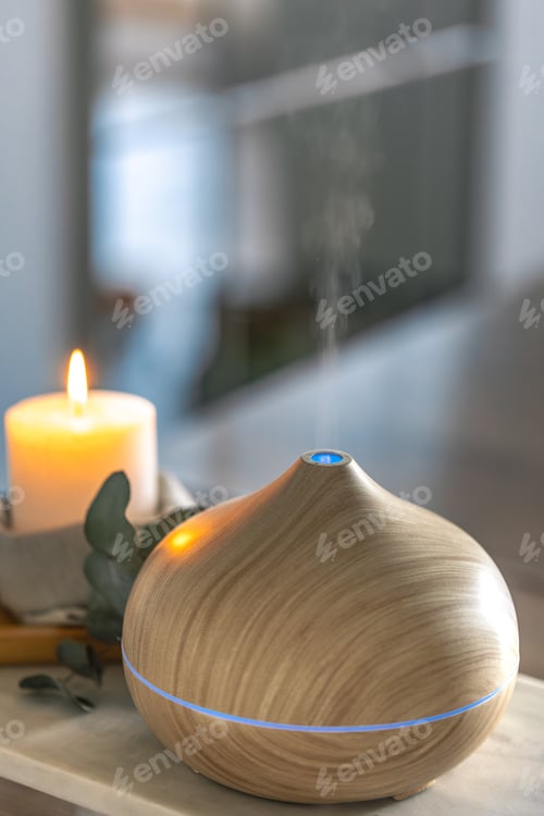 Preview: Modern wooden aroma diffuser releasing steam in cozy interior for relaxation. Diffuser spa mood.