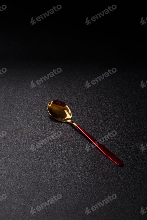 Preview: Steel spoon or teaspoon with red handle on dark concrete background