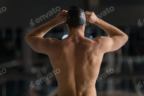 Preview: Rear view of a male swimmer adjusting his goggles