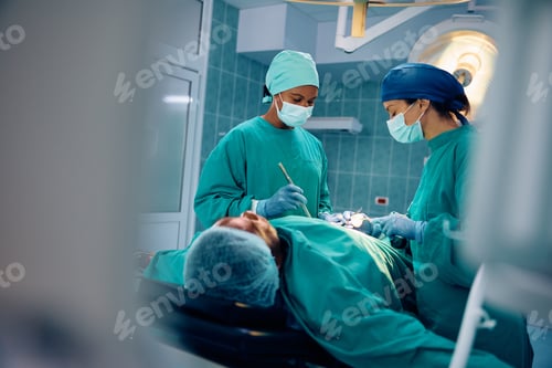 Preview: Female medical experts cooperating while performing surgery in the hospital.