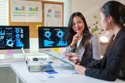 Preview: Businesswomen analyzing financial data, collaborating on strategy