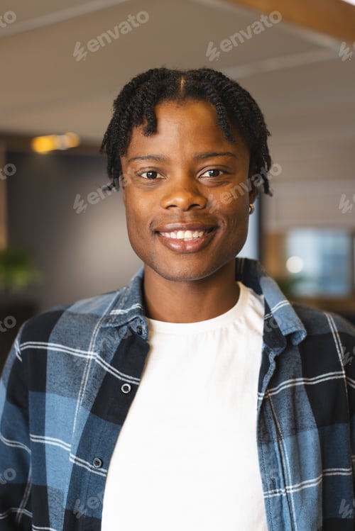 Preview: African American man wearing plaid shirt over white tee, smiling