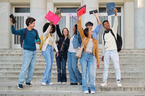 Preview: Diverse university students celebrating graduation success on campus steps