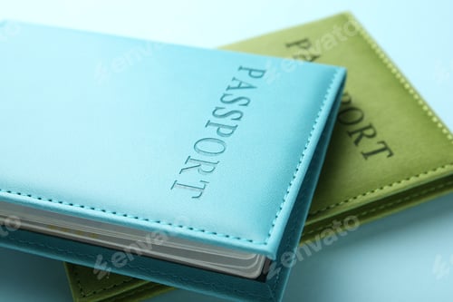 Preview: Passports in color covers on light blue background, closeup