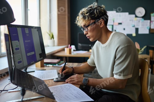 Preview: Young Adult Caucasian Man Designing Mobile Application Interface on Computer