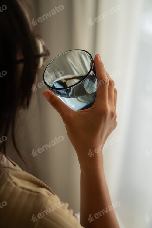Preview: Woman holding a glass of pure mineral water
