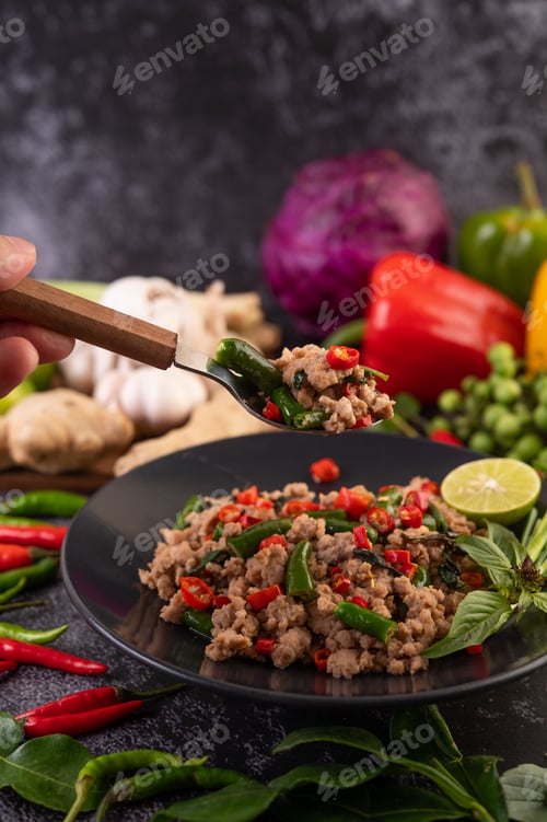 Preview: Stir-fried pork basil on banana leaves in a black dish.