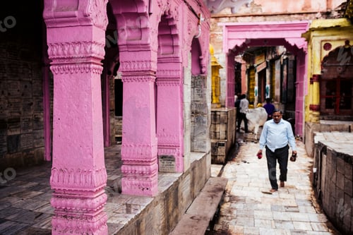 Preview: Man walking through a vibrant pink alleyway