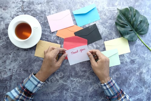 Preview: top view of man hand reading a thank you letter