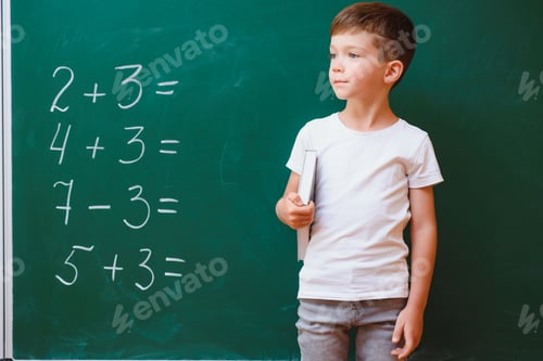 Preview: Back to school concept. School child in class. Happy kid against green blackboard.