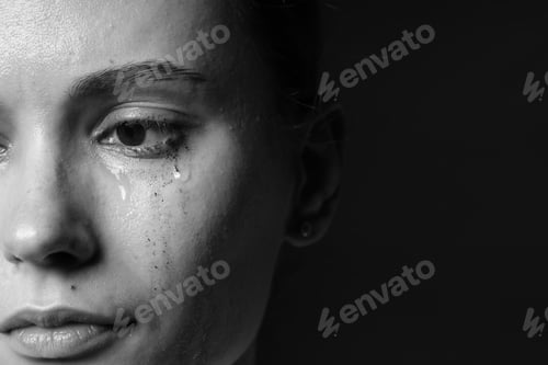 Preview: Sad woman crying on dark background, closeup. Black and white effect
