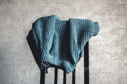 Preview: Knitted Sweater on Chair in front of Grey Wall